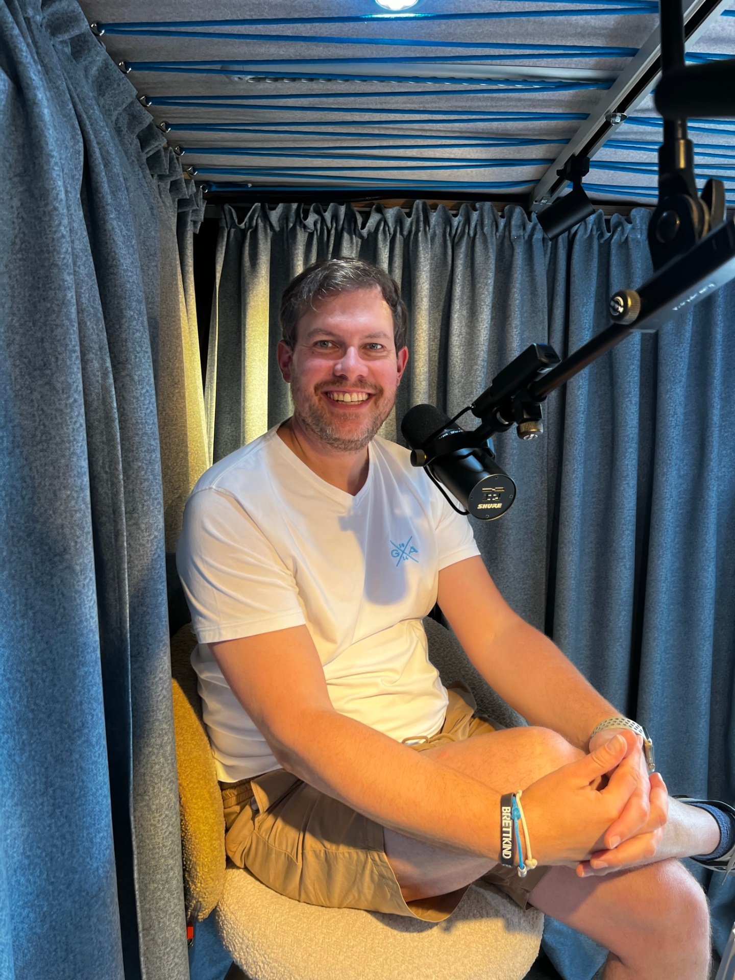 Podcast recording in mobile studio - smiling man with microphone