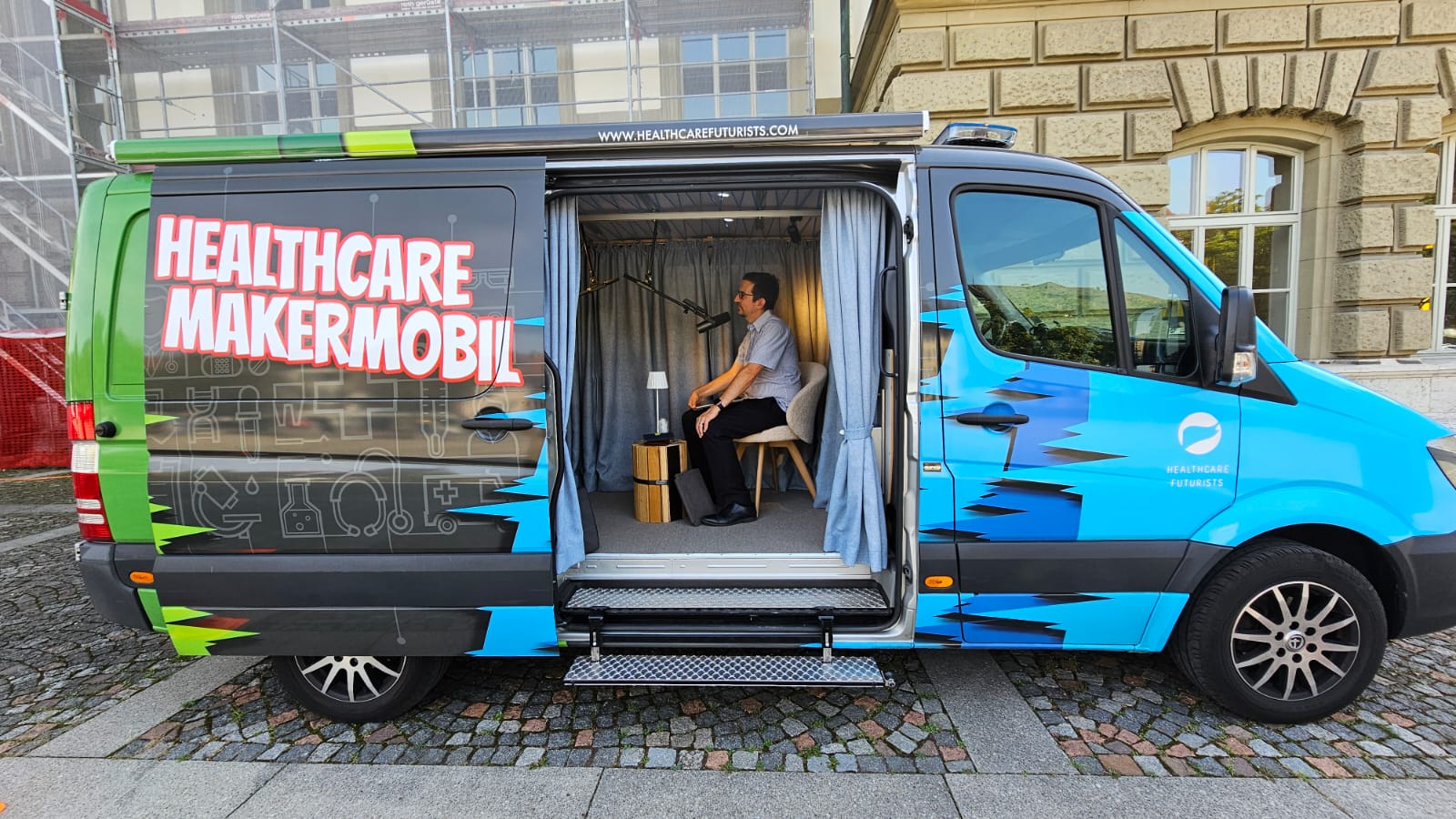 Side view of Healthcare Maker Mobil van with person inside